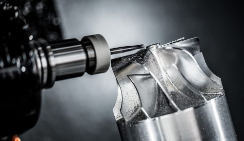 5-axis CNC machining center cutting a curved aluminum housing