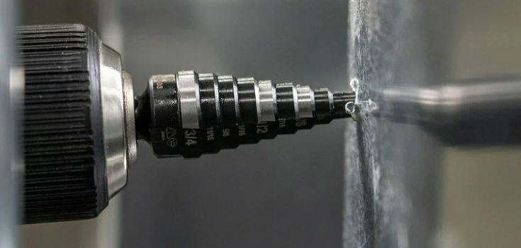 step drill bit in action on metal surface