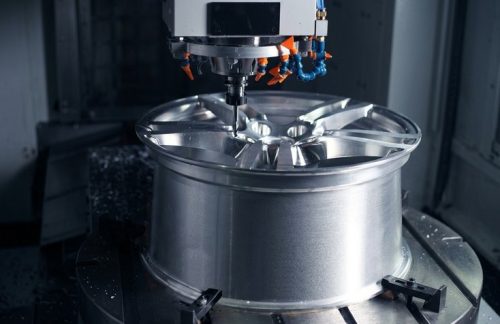 CNC machine milling aluminum wheel rim with coolant spray