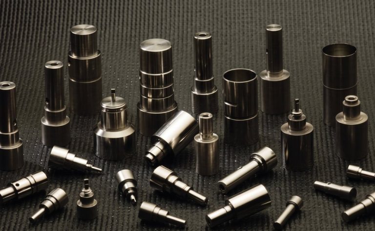 Stainless steel CNC machined aerospace components on textured surface