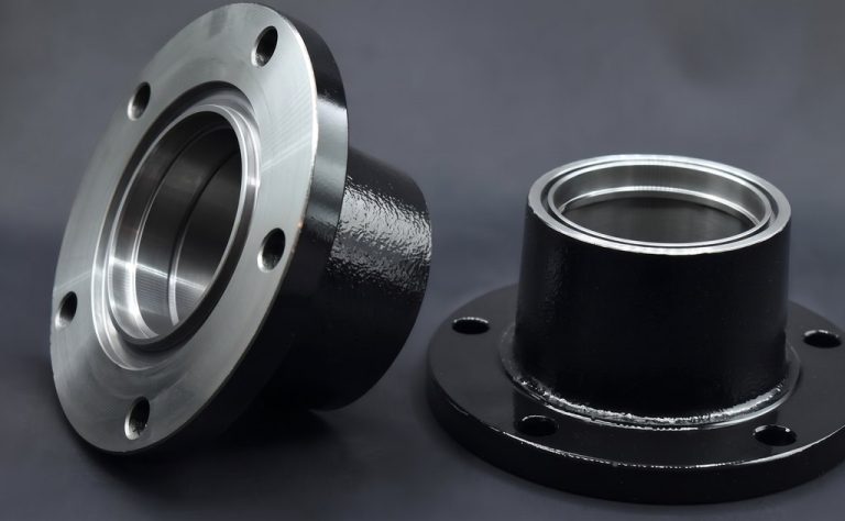 Two machined flanges, one silver, one black, isolated