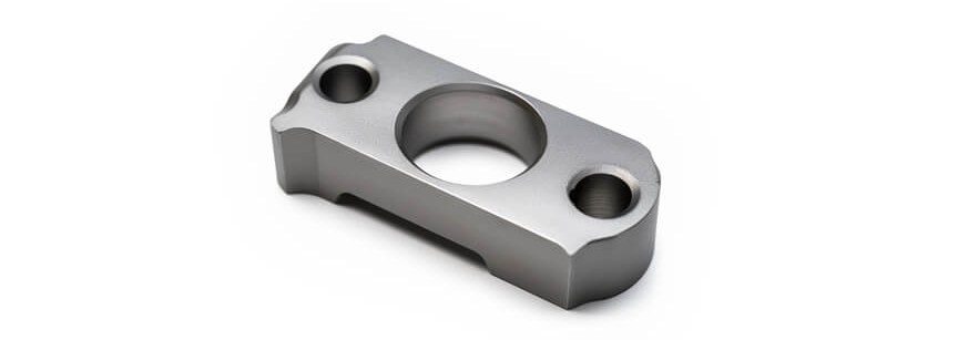 Machined alloy steel bracket on white background