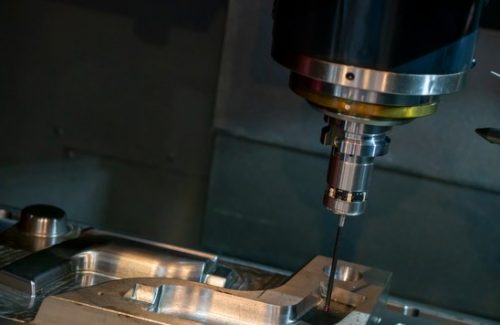 Vertical CNC milling spindle machining an aluminum workpiece