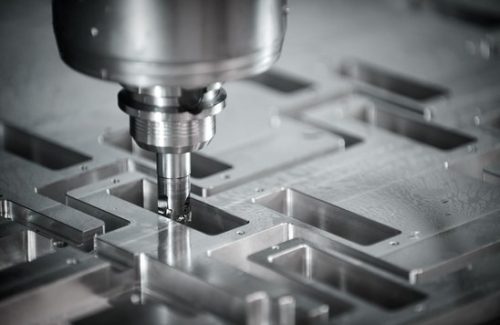 CNC end mill cutting pockets in an aluminum plate