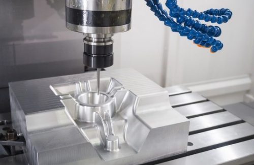 CNC milling of a large aluminum block on a machine table