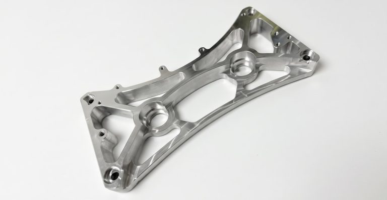 CNC machined metal automotive bracket with precision cutouts
