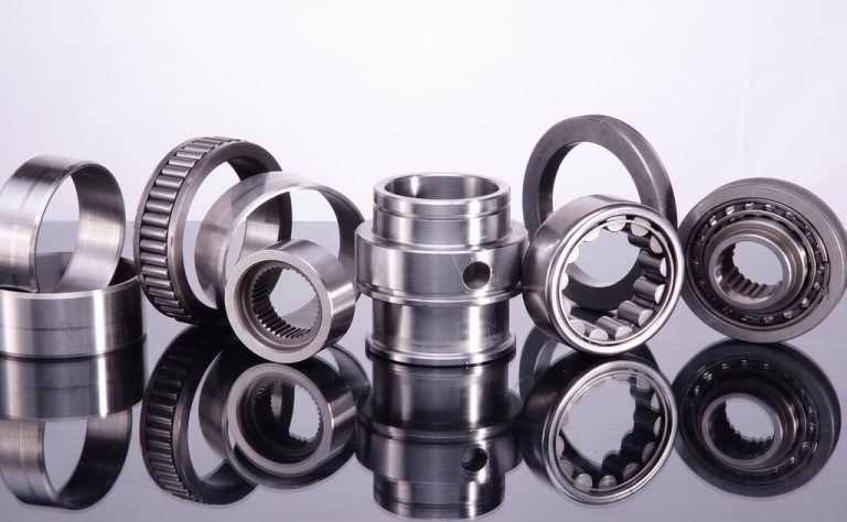 Precision machined metal bearings and bushings on reflective surface