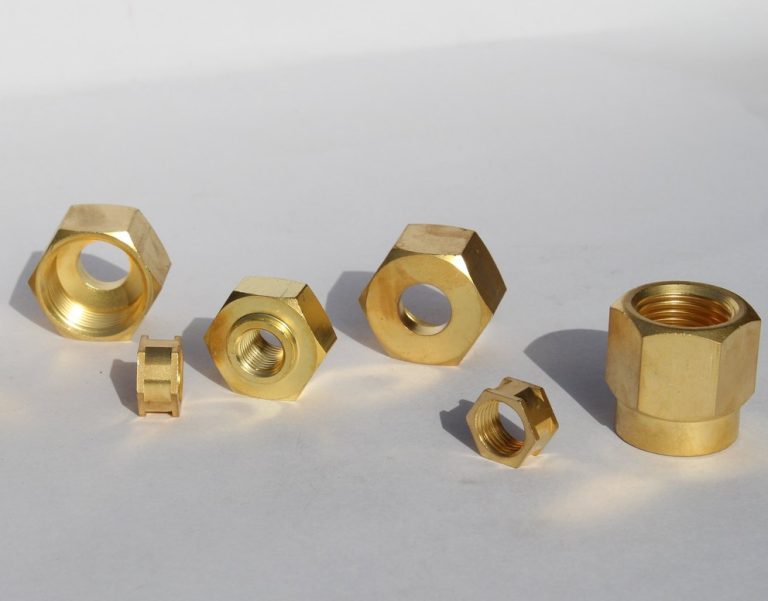 Brass machined fittings and nuts on white background