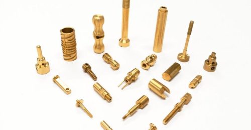 Brass machined parts arranged on white background