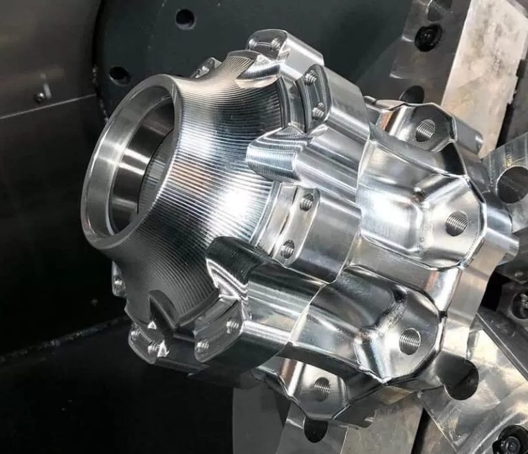 Finished CNC machined stainless steel flange on dark worktable