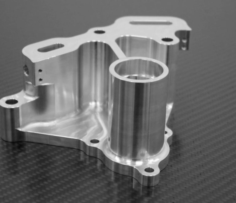 Precision CNC milled aluminum housing part on dark table