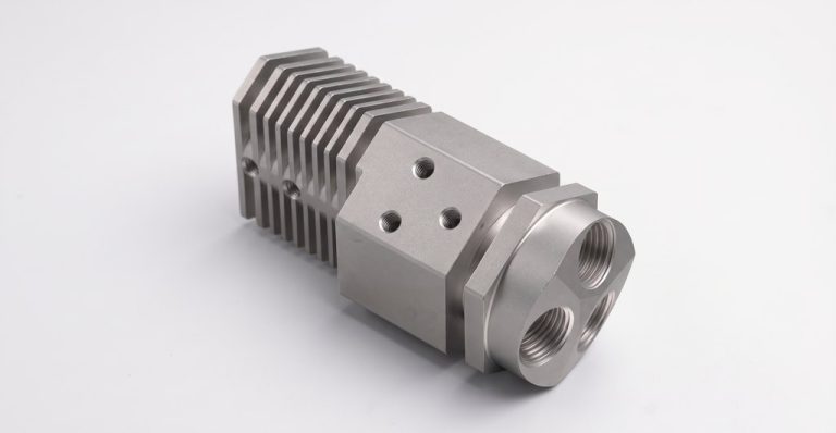 CNC machined metal part with fins and threaded ports