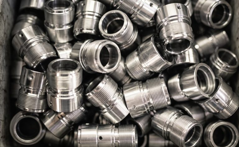 Stainless steel threaded fittings piled together on surface