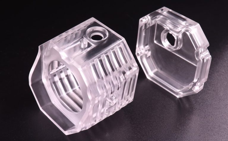 Two clear machined polycarbonate parts with precise cutouts