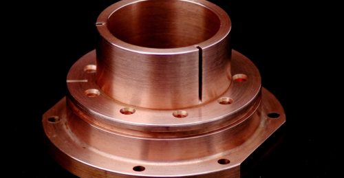 Copper machined part with flange and slots