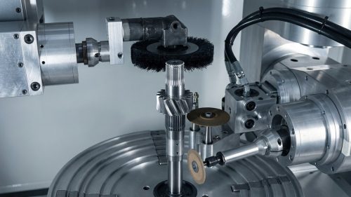 Rotary brush tool deburring a machined steel gear on CNC lathe