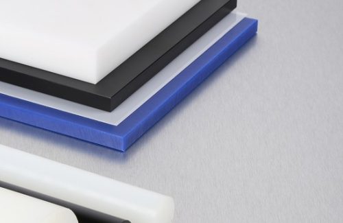 Acetal plastic sheets and rods stacked on metal surface