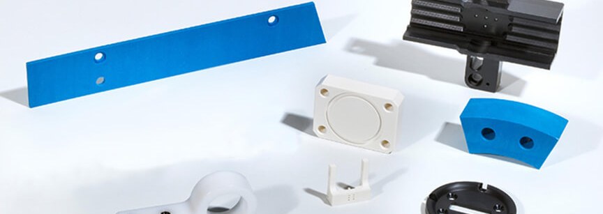 Assorted machined plastic parts on white background