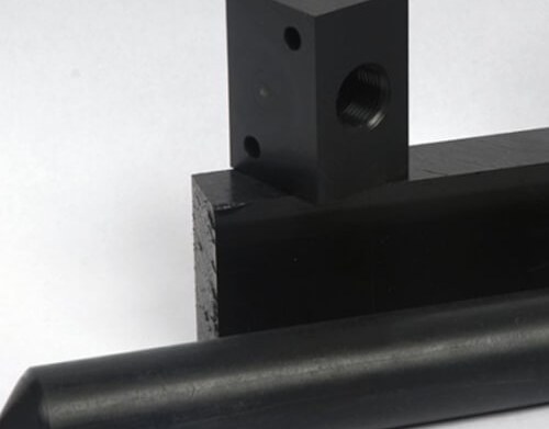 Black acetal machined parts on white background