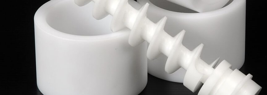 White acetal plastic machined parts on black surface