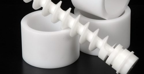 White acetal plastic machined parts on black surface