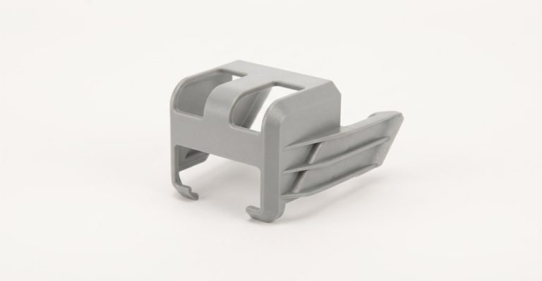 Gray plastic drone component with machined slots and curves
