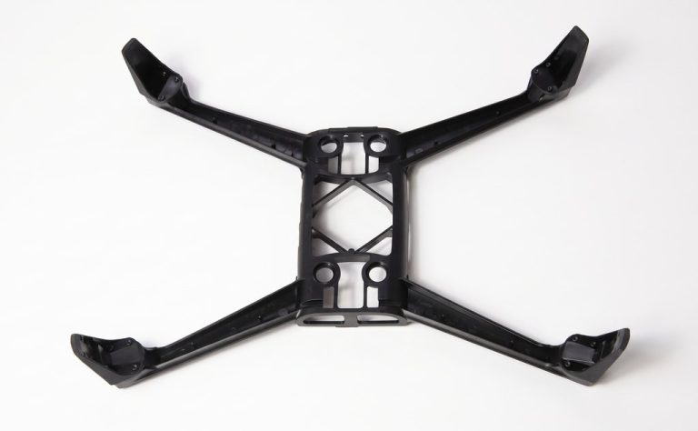 Black CNC-machined drone frame with four arms and mounting holes