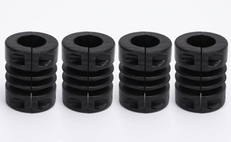 Four black machined plastic couplings with split design