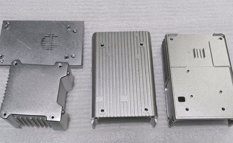 Three machined aluminum electronic enclosures with textured surfaces