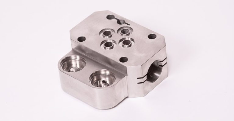 Precision machined steel component with multiple bores and threaded features
