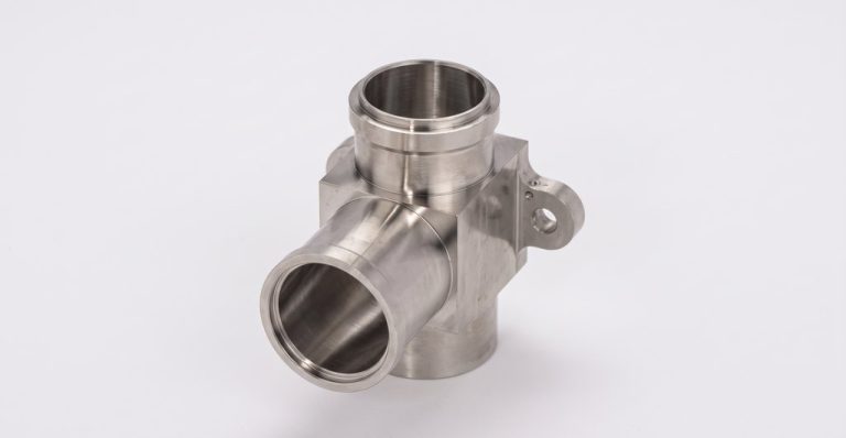 Stainless steel machined fitting with three ports and mounting flange