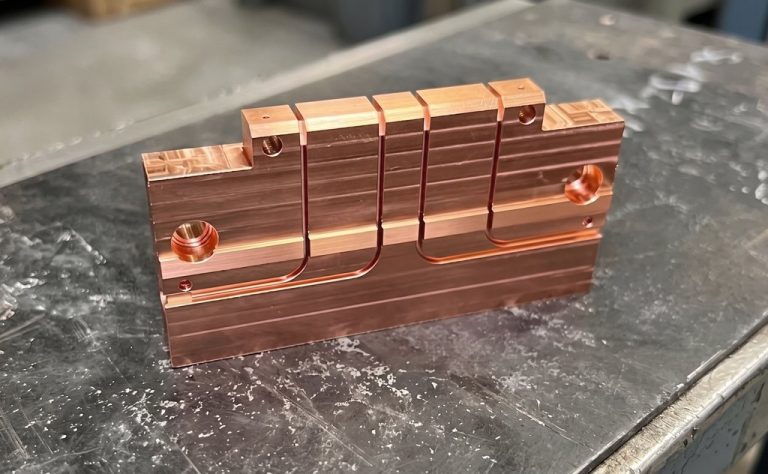 Copper machined part with slots holes and curved channels