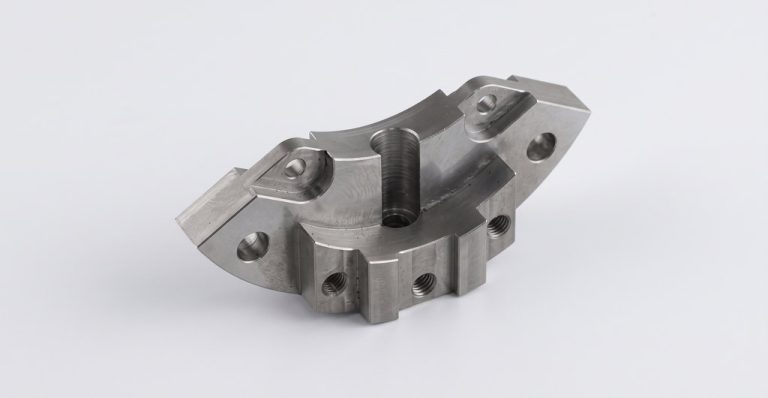 Machined metal bracket with threaded holes and smooth surfaces