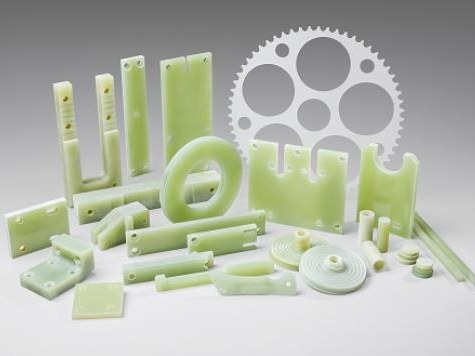 Assorted machined G-10 plastic parts on white