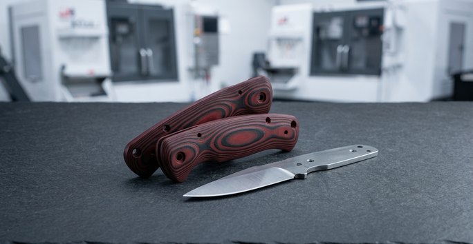 Colored G10 Garolite knife handle scales on worktable