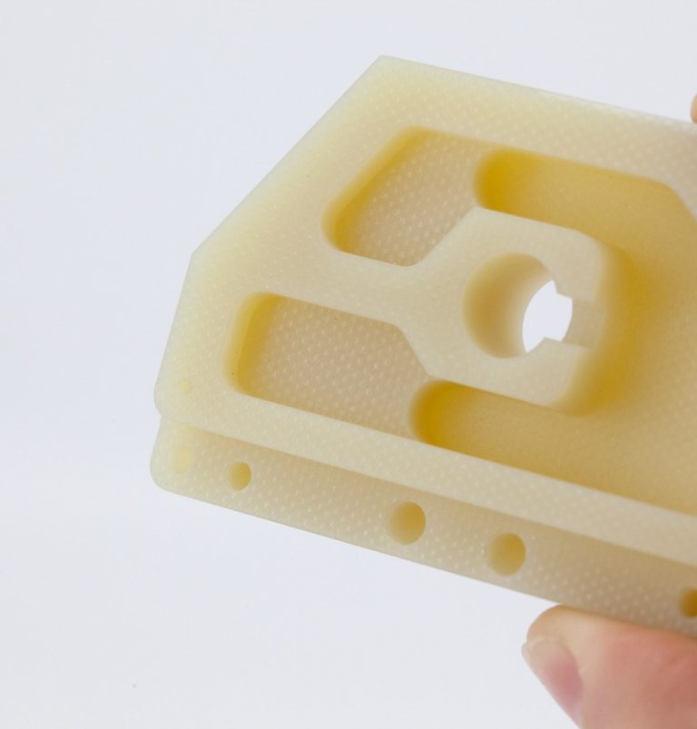 Hand holding a machined G10 plastic part