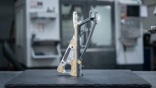 Spray painting aluminum bracket showing bare metal and painted finish