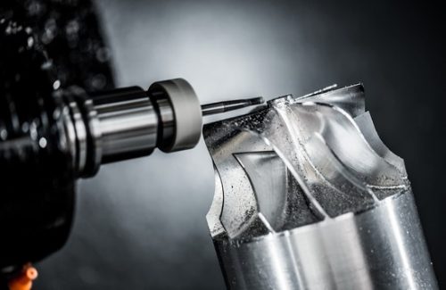 5-axis CNC milling tool cutting a curved aluminum surface