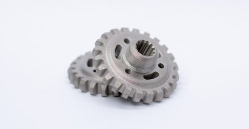 Two machined metal gears on white background