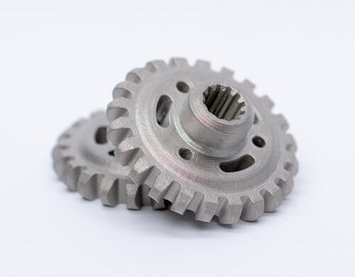 Two machined metal gears on white background