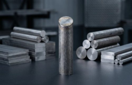 Raw Inconel 718 round bar stock on dark surface