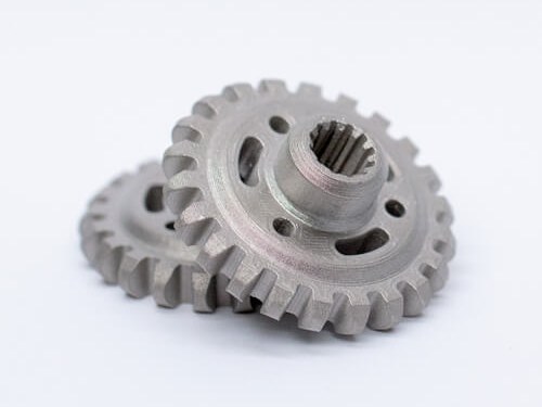 Two machined metal gears on white background