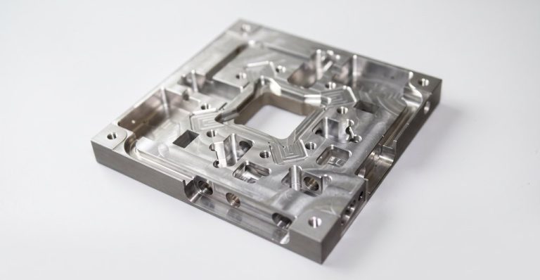 Precision machined aluminum base plate with multiple cavities and threaded holes