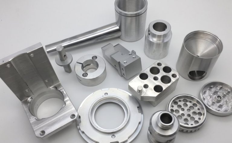 Assorted CNC machined metal parts with precision holes and threads