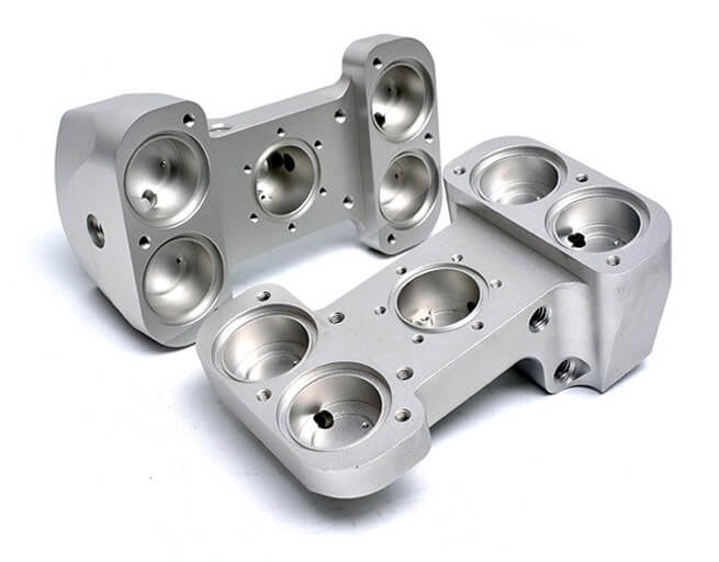 Two complex cnc-machined invar parts on white