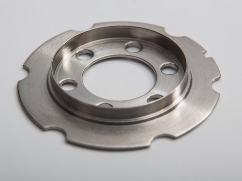 Metal machined flange with scalloped edge and holes