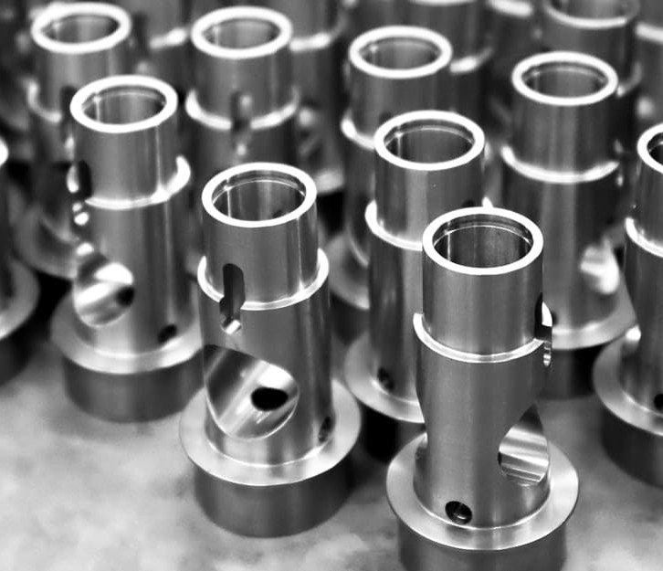 Finished low volume CNC machined parts on dark workbench