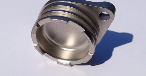 Metal machined part with flange and internal threads