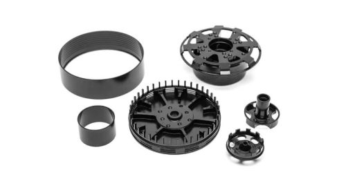 Black machined magnesium parts on white background