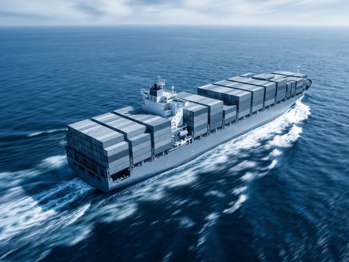 Marine industry: a large modern container ship ploughing through deep blue ocean waves